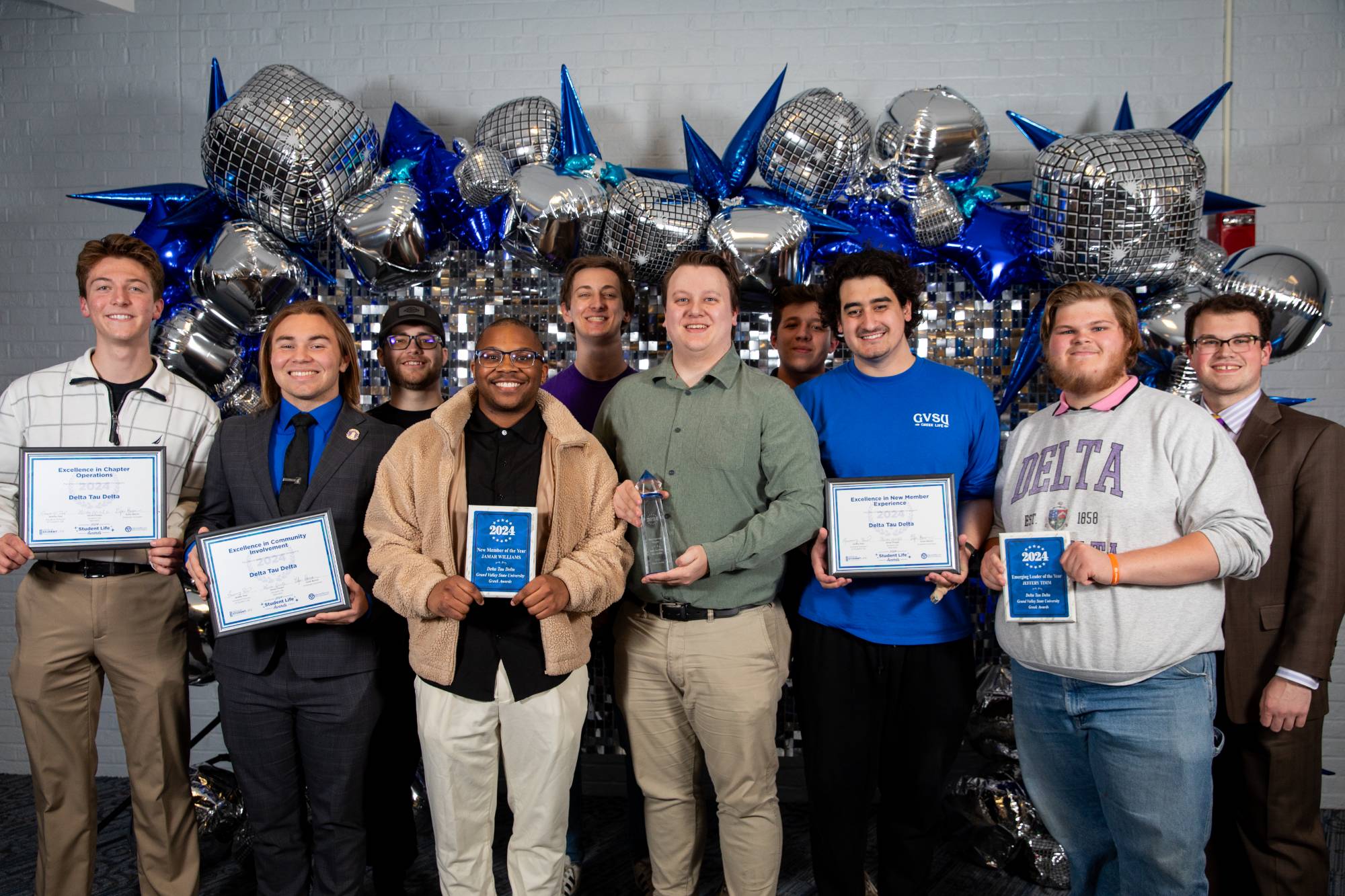 A group of greek life students holding awards
